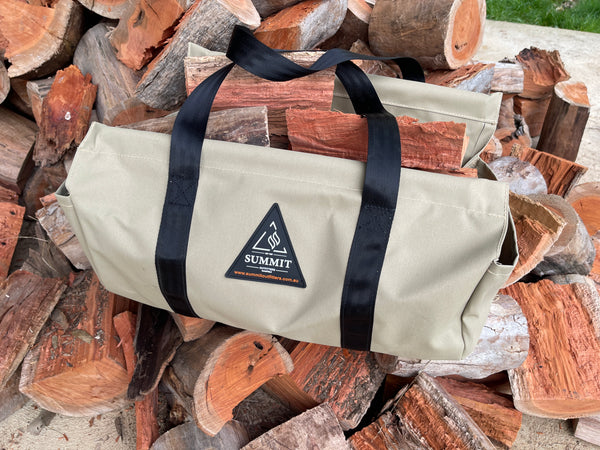 Beige wood carrier with black straps holding logs of food on a pile of firewood