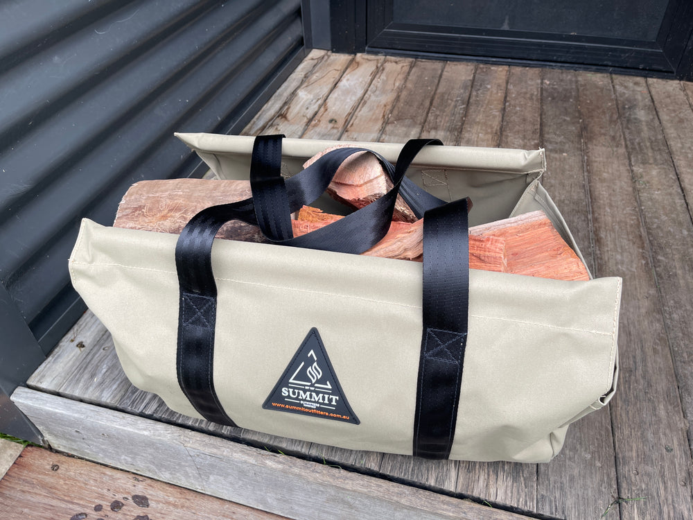 Beige carrying bag with black straps holding firewood, branded 'Summit', on a wooden step.
