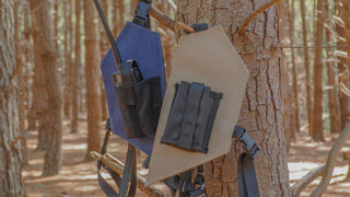 Blue and Sand Radio Holsters attached to a tree in a forest setting