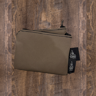 Two brown canvas pencil cases with a zipper closure, placed on a wooden surface.