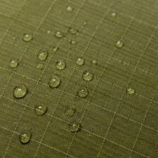 Green fabric with water droplets demonstrating water resistance.
