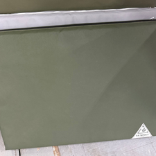 green and grey canvas dog beds leaning on wall. 