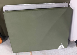 green and grey canvas dog beds leaning on wall. 