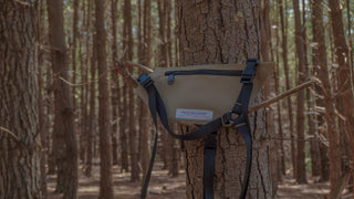 Beige radio holster attached to a tree in a forest setting